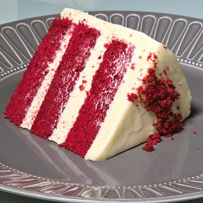 Slice of Japanese red velvet chiffon cake showing red sponge layers and cream cheese frosting